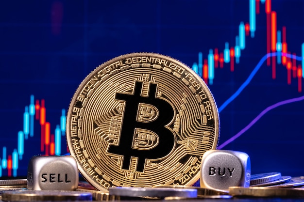 Un bitcoin dorato con due dadi in una pila di monete sullo sfondo il grafico azionario con candelieri. Sui bordi dei dadi ci sono le parole "comprare" e "vendere". Il concetto di scelta di compravendita.