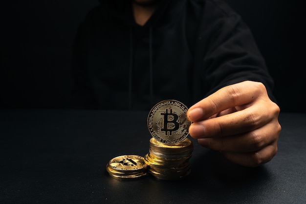 Un bitcoin dorato nella mano di un uomo misterioso, finanza digitale