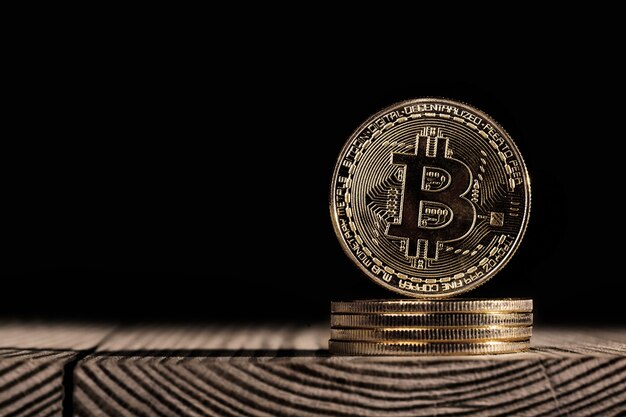 Un bitcoin sulla tavola di legno isolata sul nero