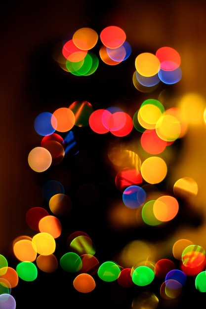 Un bokeh di blu verde e giallo sullo sfondo un nuovo albero di Natale è sfocato