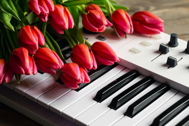 Un bouquet di bei tulipani rosa sui tasti del pianoforte primavera concept musica di sottofondo