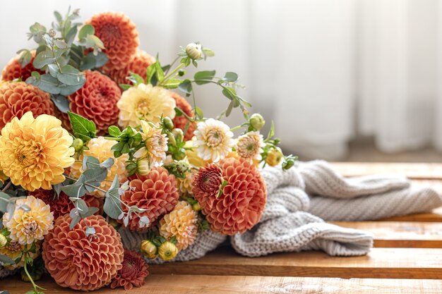 Un bouquet di crisantemi gialli e arancioni su uno sfondo sfocato.