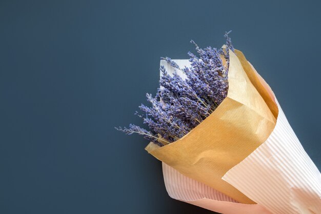 Un bouquet di lavanda secca in carta su uno sfondo scuro