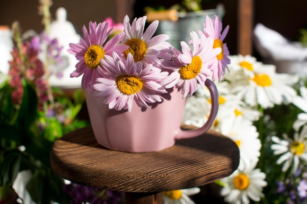 Un bouquet di margherite colorate in un vaso Bancone di un negozio di fiori dall'arredamento rustico