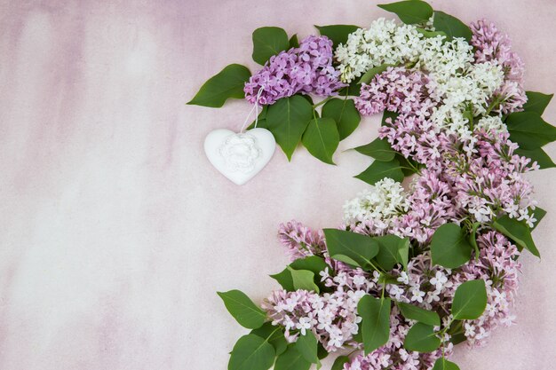 un bouquet di rosa lilla e bianco lilla, cuore in ceramica bianca