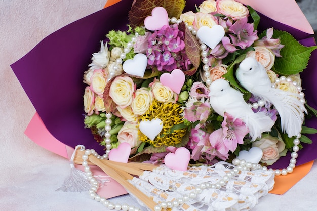 Un bouquet di rose, ortensie e due colombe bianche, cuori di raso, perle