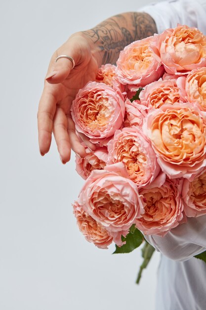 Un bouquet di rose rosa media, una ragazza con un bellissimo bouquet tra le mani. Concetto di festa della mamma, vacanza