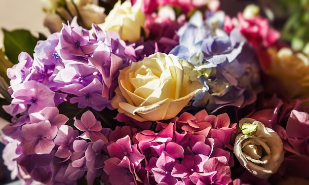 Un bouquet festivo di un mazzo di rose e ortensie sotto i raggi del sole. Sfondo di fiori