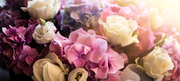 Un bouquet festivo di un mazzo di rose e ortensie sotto i raggi del sole. Sfondo di fiori