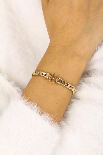 Un braccialetto con una catena d'oro con sopra la scritta love.