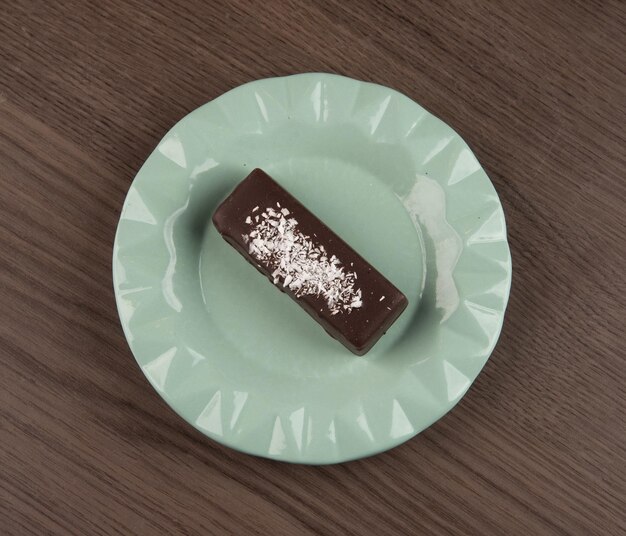 Un brownie al cioccolato su un piatto verde.