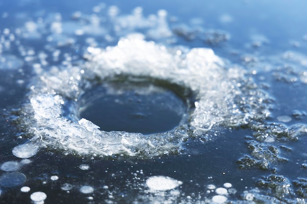 Un buco in uno stagno ghiacciato per la pesca Pesca invernale