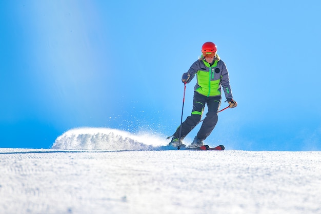 Un buon sciatore in azione sposta la neve polverosa in pista