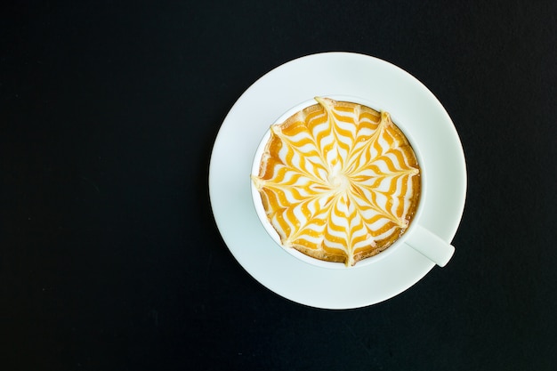 Un caffè di latte sul tavolo nero.