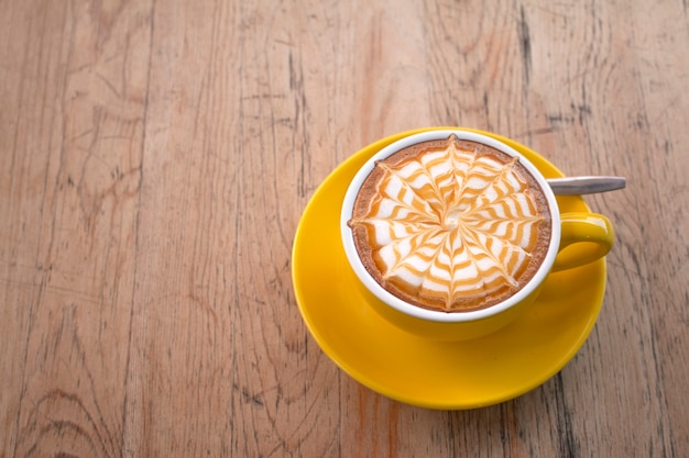 Un caffè di latte sulla scrivania in legno