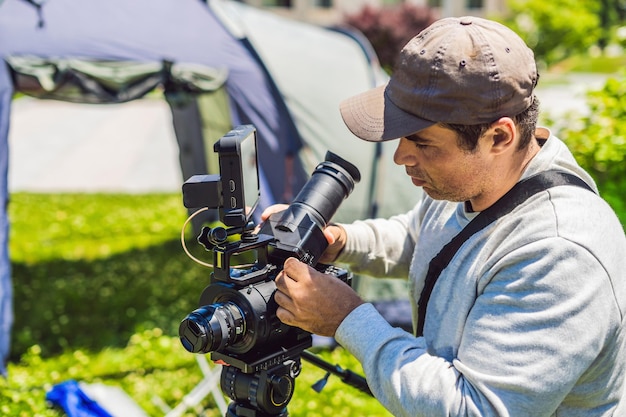 Un cameraman professionista prepara una macchina fotografica e un treppiede prima delle riprese.