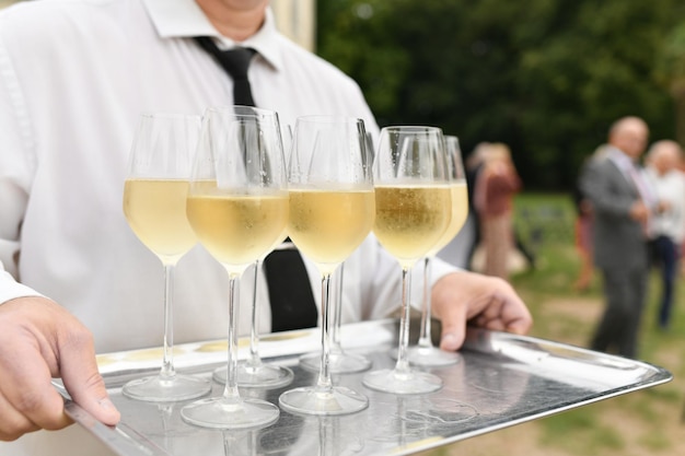 Un cameriere che serve champagne a un matrimonio