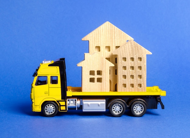 Un camion carico trasporta case. Concetto di trasporto e spedizione merci, società di traslochi