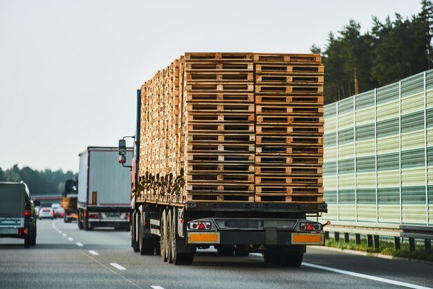 Un camion che trasporta un carico di pallet europei su autostrada Un camion che trasportano un carico di palette europee su strada