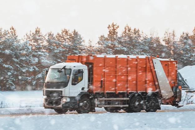 Un camion della spazzatura sanitaria attraversa la bellezza serena di un paesaggio innevato Gli alberi carichi di neve dipingono uno sfondo pacifico