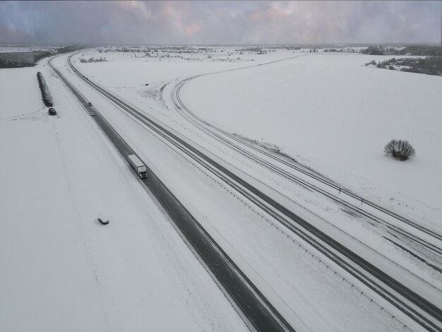 Un camion guida lungo l'autostrada che porta a Tallinn in inverno foto da un drone foto di alta qualità