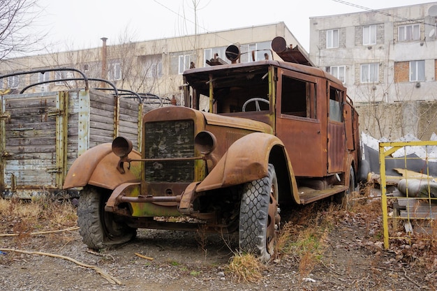 Un camion sovietico d'epoca arrugginito è abbandonato da edifici industriali