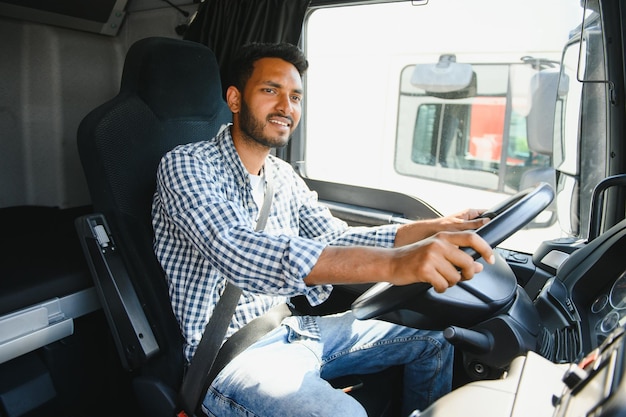 Un camionista professionista felice che guida il suo camion.