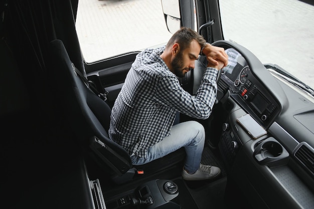 Un camionista stanco che guida in una cabina del suo camion.