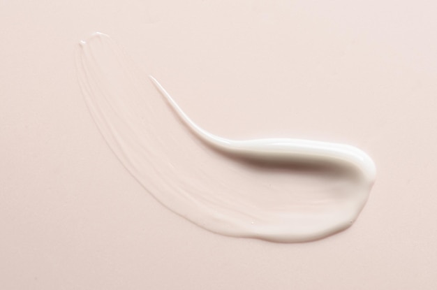 Un campione di crema idratante su sfondo rosa Prodotto cosmetico per la pelle