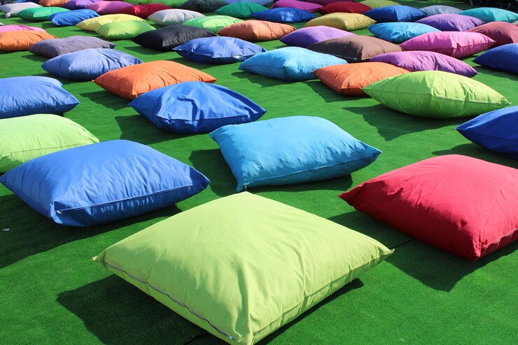 Un campo di cuscini colorati su un prato con uno che dice "ti amo"