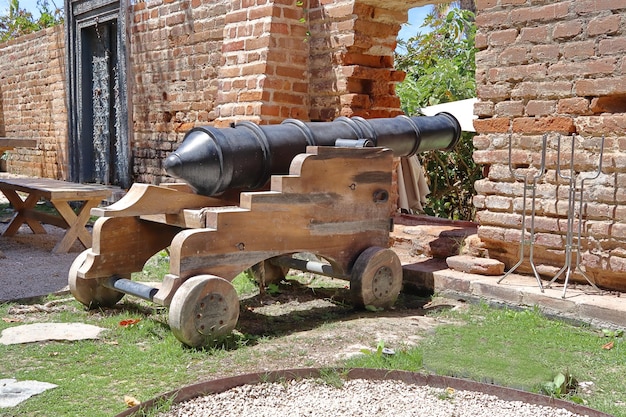 Un cannone è in mostra davanti a un edificio in mattoni