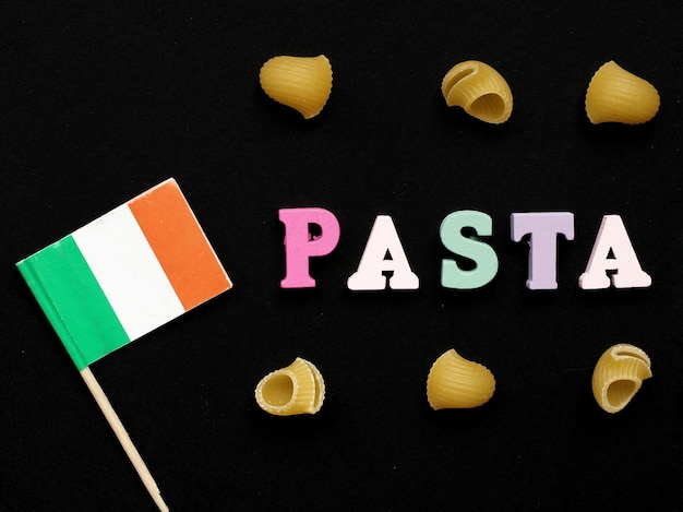 Un cartello con la bandiera italiana e la parola pasta su sfondo nero