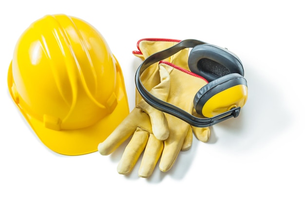 Un casco giallo guanti da lavoro e auricolari isolati su sfondo bianco