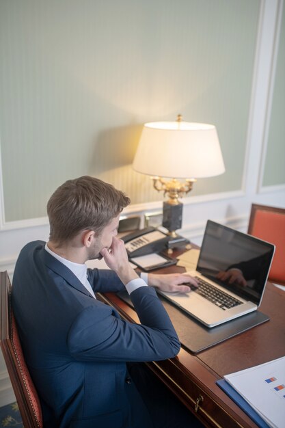 Un CEO premuroso che lavora con il suo computer nel suo armadietto