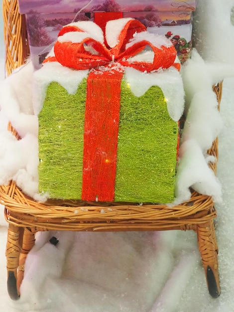 Un cesto con un regalo avvolto nella neve si trova su una slitta.