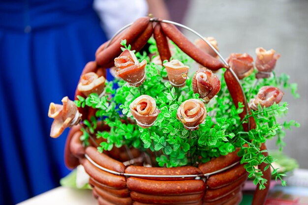 Un cesto festivo di prodotti a base di carne splendidamente decorato con vegetazione