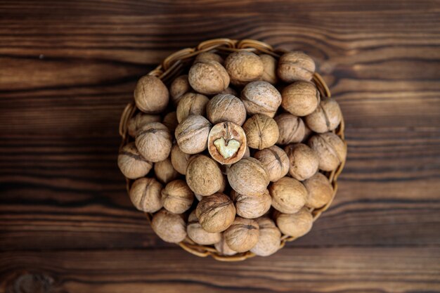 Un cesto pieno di noci su uno sfondo di legno