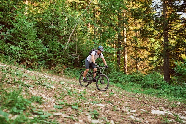 Un ciclista guida una bicicletta su strade forestali estreme e pericolose. Messa a fuoco selettiva. Foto di alta qualità