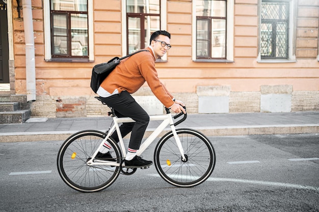 Un ciclista maschio va al lavoro con una valigetta Urban ecotransport