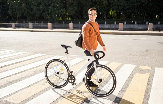 Un ciclista maschio va in bicicletta per lavorare nell'ecotrasporto cittadino