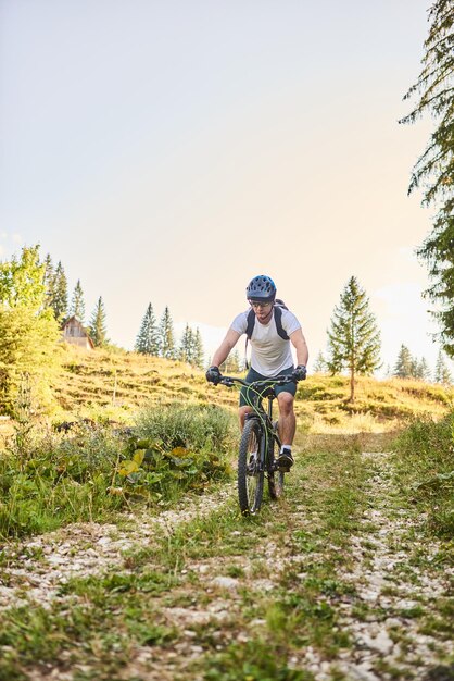 Un ciclista va in bicicletta su strade forestali estreme e pericolose Messa a fuoco selettiva