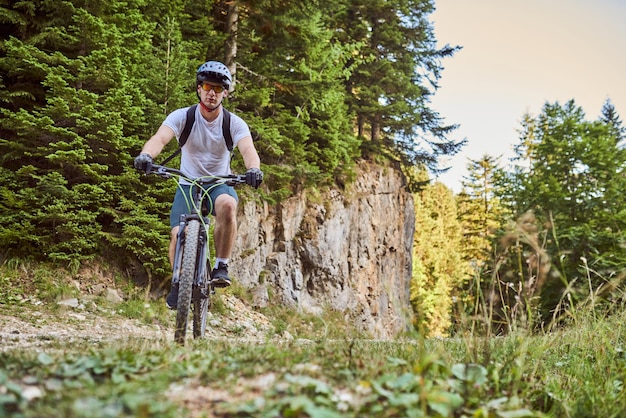 Un ciclista va in bicicletta su strade forestali estreme e pericolose Messa a fuoco selettiva