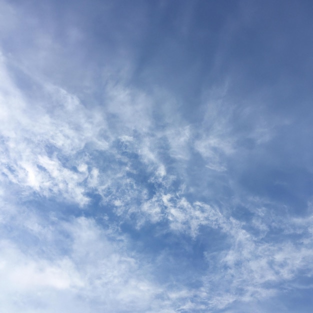 Un cielo azzurro con nuvole bianche esili e qualche nuvola.