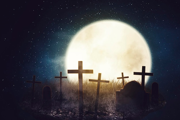 Un cimitero inquietante con la croce e la luna piena nella buia notte di Halloween.