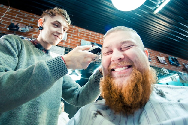 Un cliente dai capelli rossi si fa tagliare i capelli dal barbiere