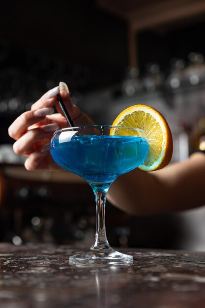 Un cocktail blu con una fetta di arancia sul lato