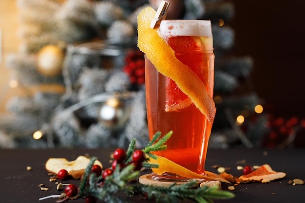 un cocktail di birra sulla tavola di Natale con un albero di Natale sfocato con luci sullo sfondo