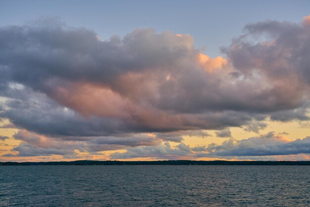Un colorato tramonto sul Mar Baltico con nuvole illuminate dal sole che tramonta all'orizzonte.