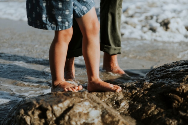 Un colpo di piedi di persone che camminano sulle rocce in spiaggia