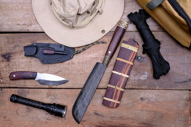 Un coltello con attrezzatura per la sopravvivenza nella foresta su un vecchio pavimento di legno